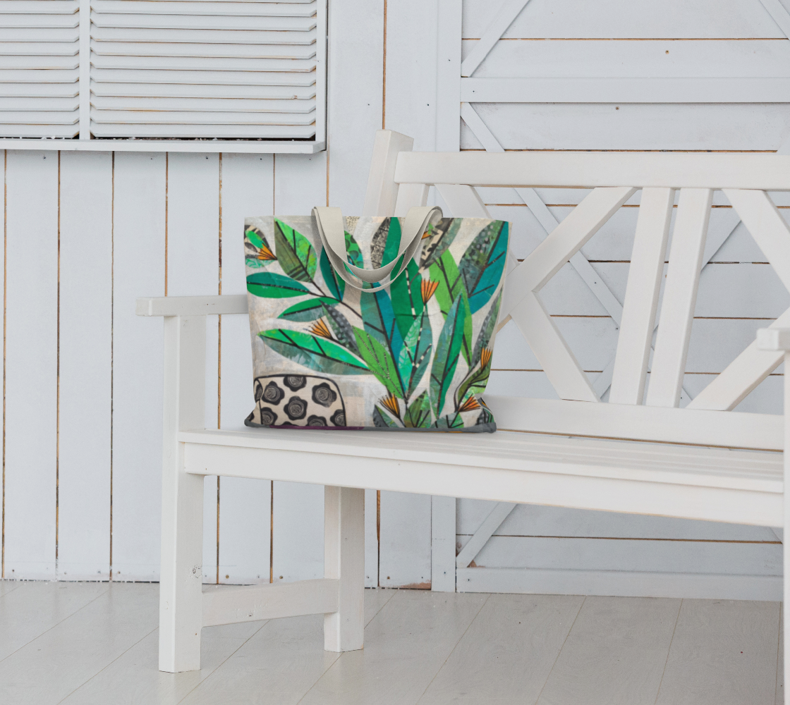 Tote bag with leaf pattern on a white bench against a white wooden wall.