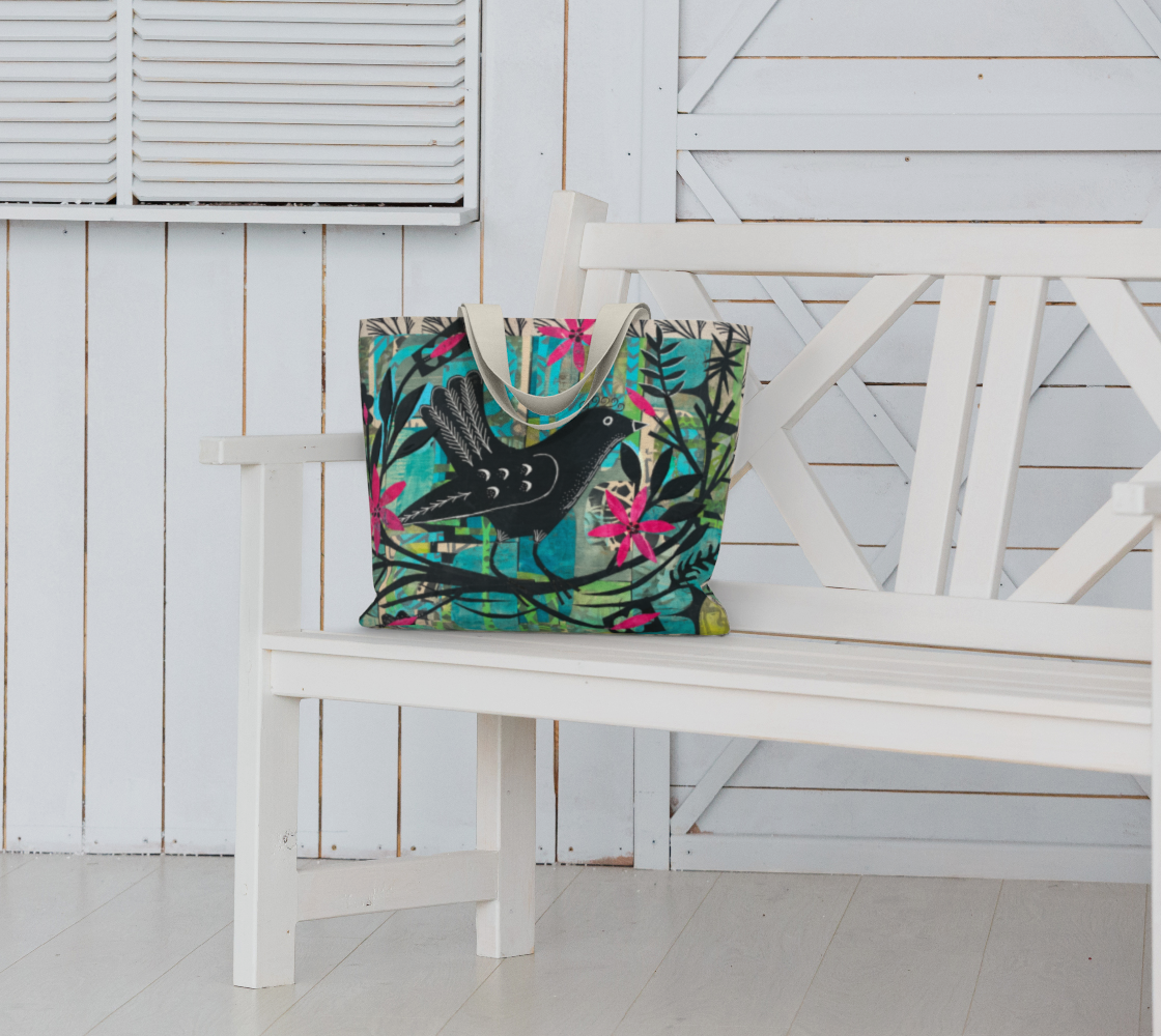 Colorful tote bag with bird design on a white bench against a white wooden wall.