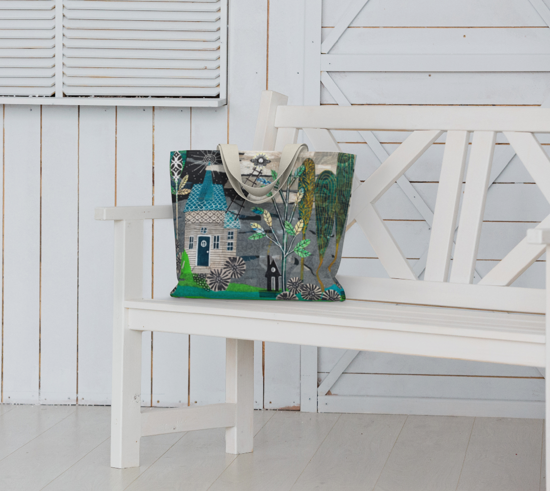 Decorative tote bag with artistic design on a white bench against a white wooden wall.