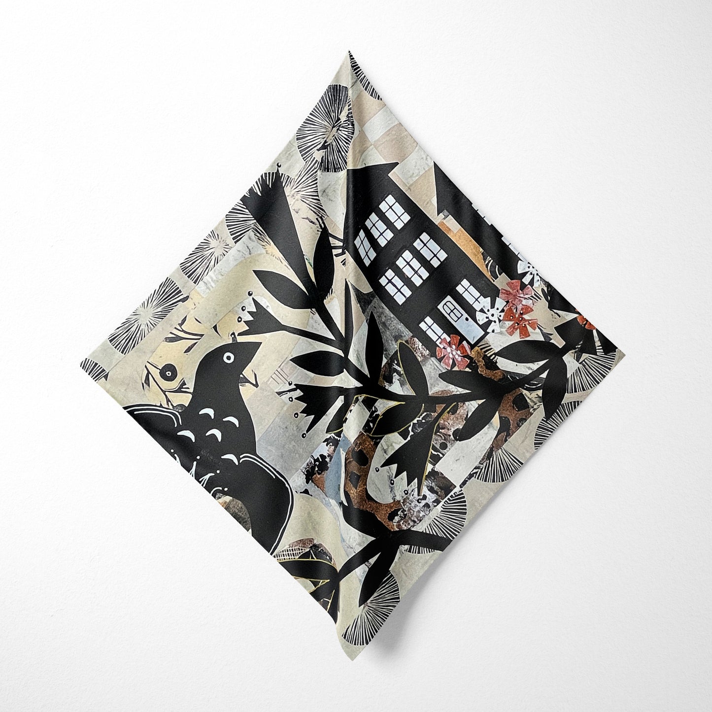 Folded fabric with a black and white pattern of birds and buildings on a white background