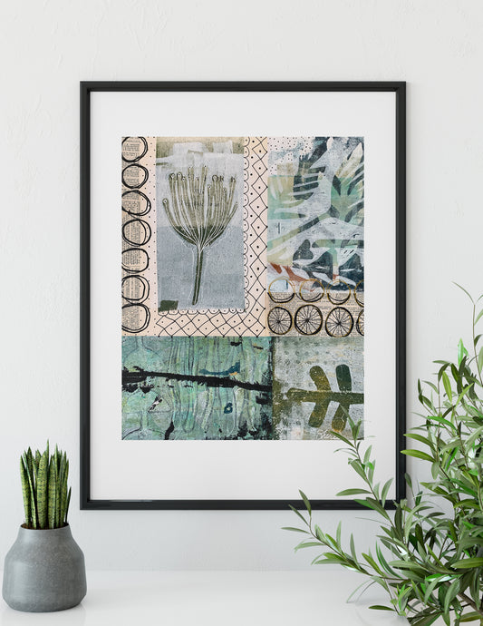 A framed art print featuring a patchwork collage of botanical and abstract designs in muted green, beige, and gray tones, displayed on a white wall above a shelf with a small potted plant and green foliage.
