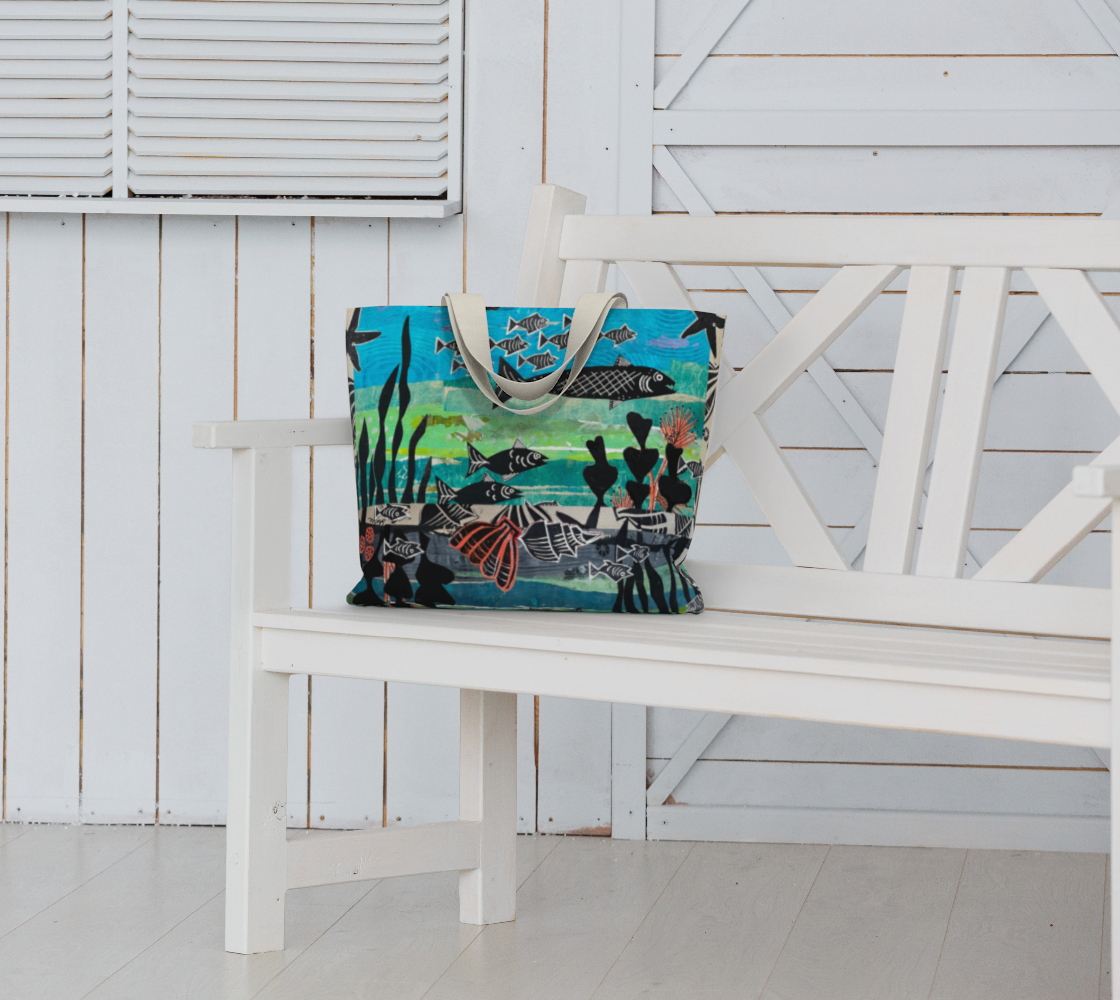 Tote bag with a fish design on a white bench against a white wooden wall.