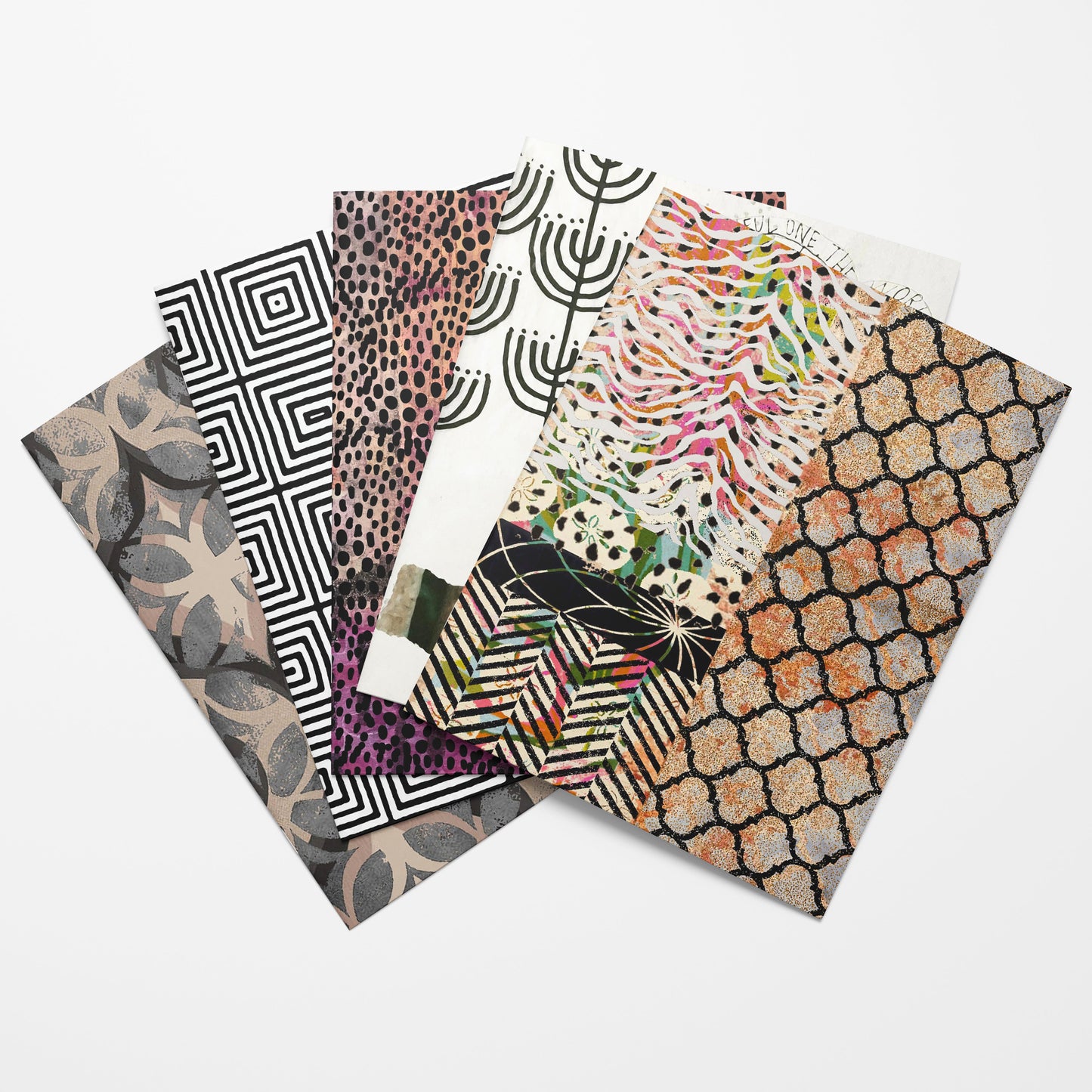 Set of four patterned notebooks stacked on a white background