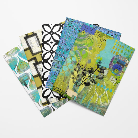 A fan arrangement of five patterned art notebooks or journals on a light gray background. The covers feature diverse abstract and geometric designs in green, blue, black, white, and yellow.