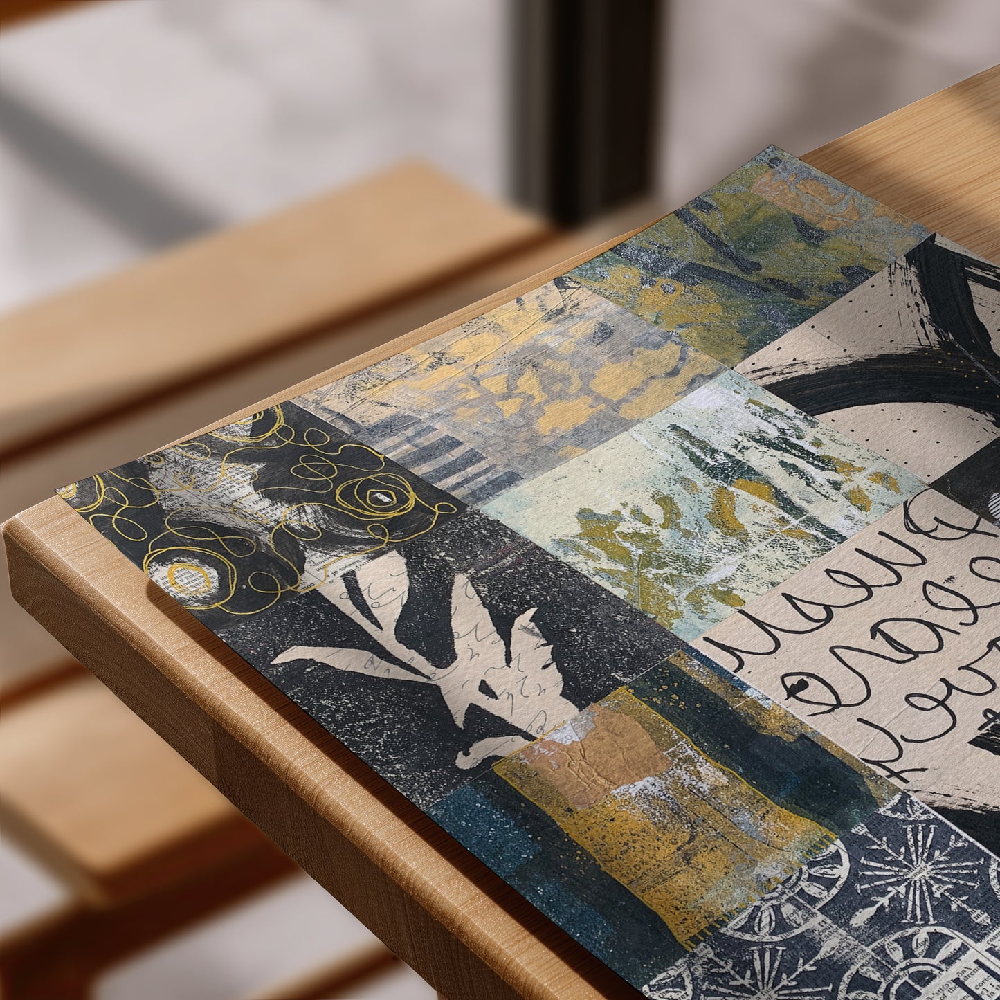 A rectangular art print with an abstract patchwork design in navy, gold, beige, and white, styled on a light wood frame.