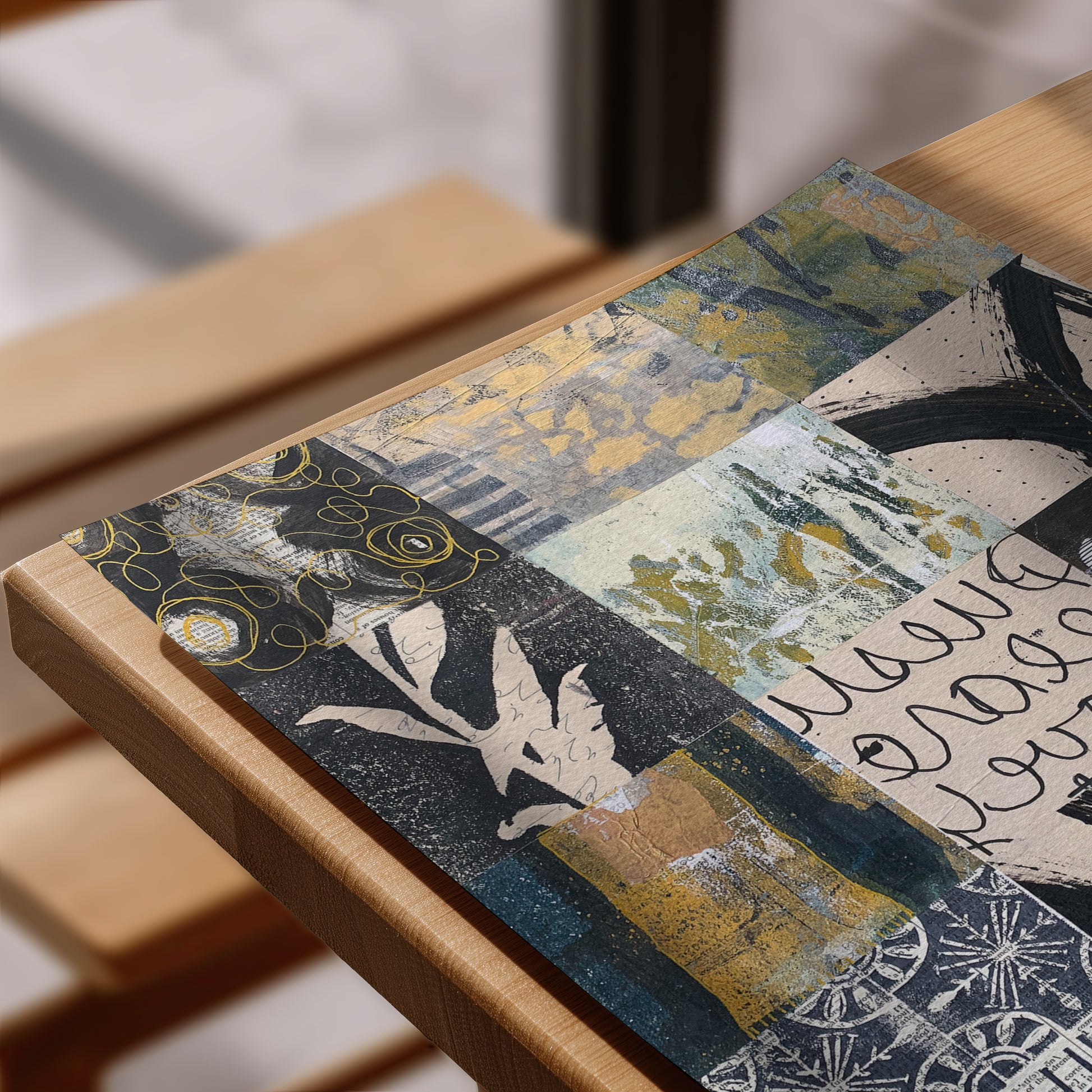 A rectangular art print with an abstract patchwork design in navy, gold, beige, and white, styled on a light wood frame.