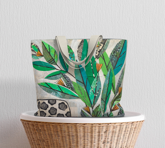 Tote bag with leaf pattern on a wicker basket against a light gray background