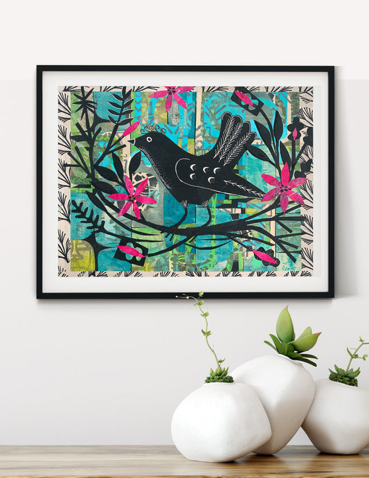 Framed wall art featuring a black bird perched on a branch with bright pink flowers and teal abstract background elements, displayed on a white wall above white ceramic planters on a wooden surface.