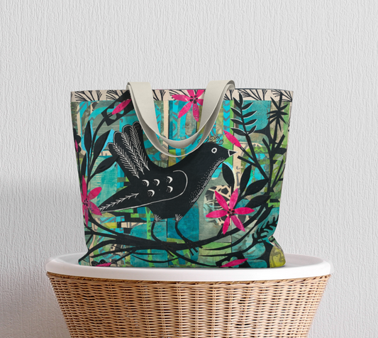 Colorful tote bag with bird design on a wicker chair against a light gray background