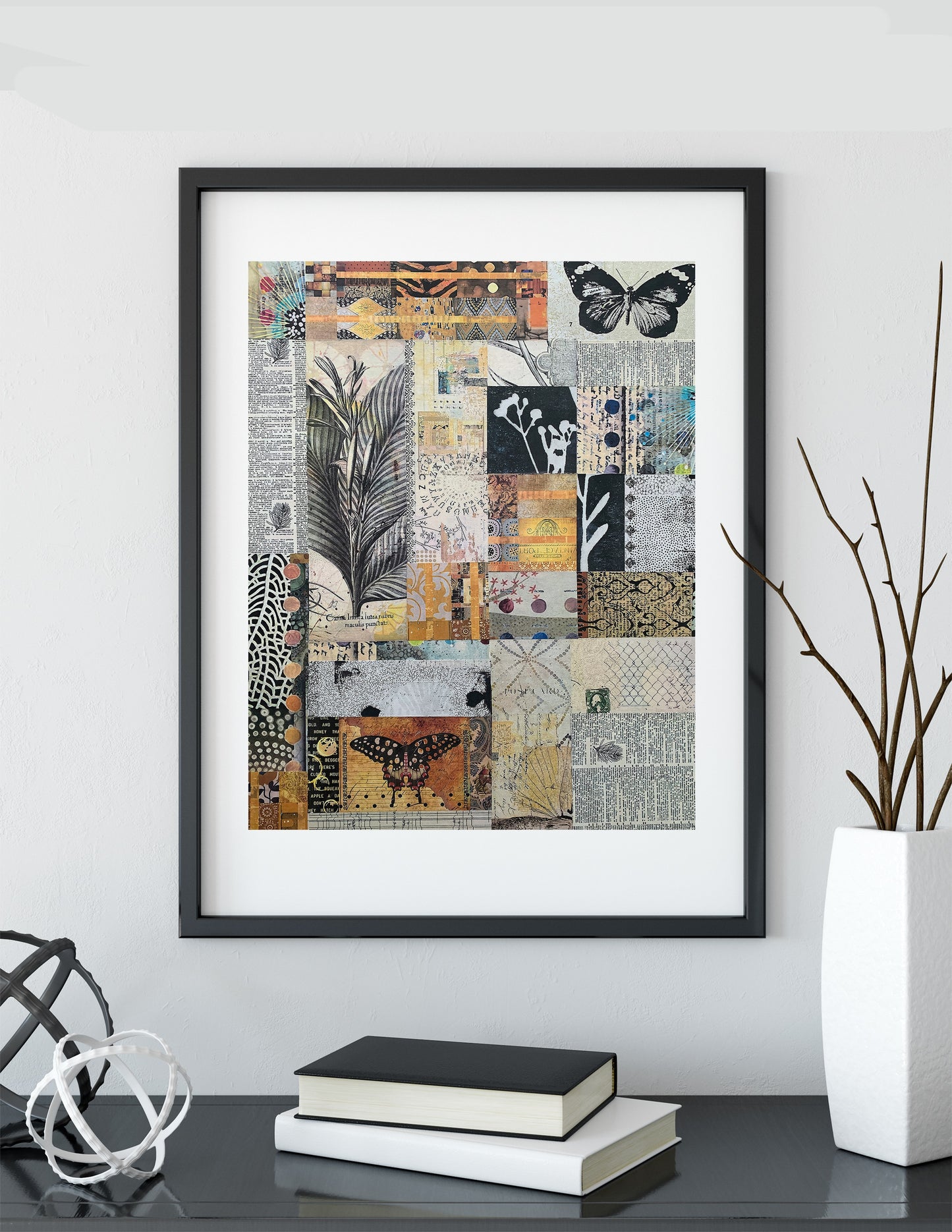 A framed rectangular mixed-media collage artwork featuring butterfly and leaf illustrations, vintage book text, geometric patterns, and textured paper panels in black, beige, orange, gray, and white.