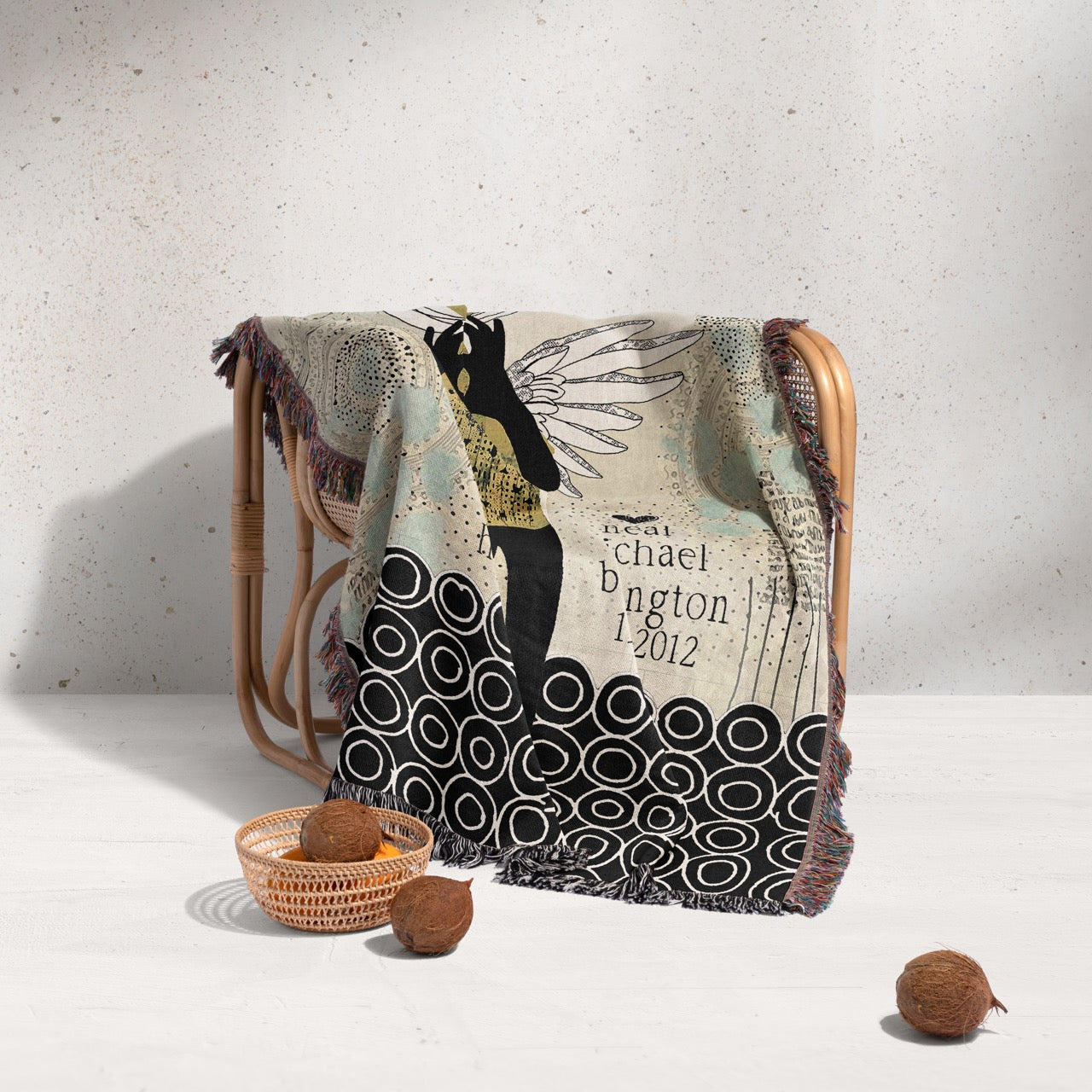 Decorative blanket with artistic design on a chair against a light background