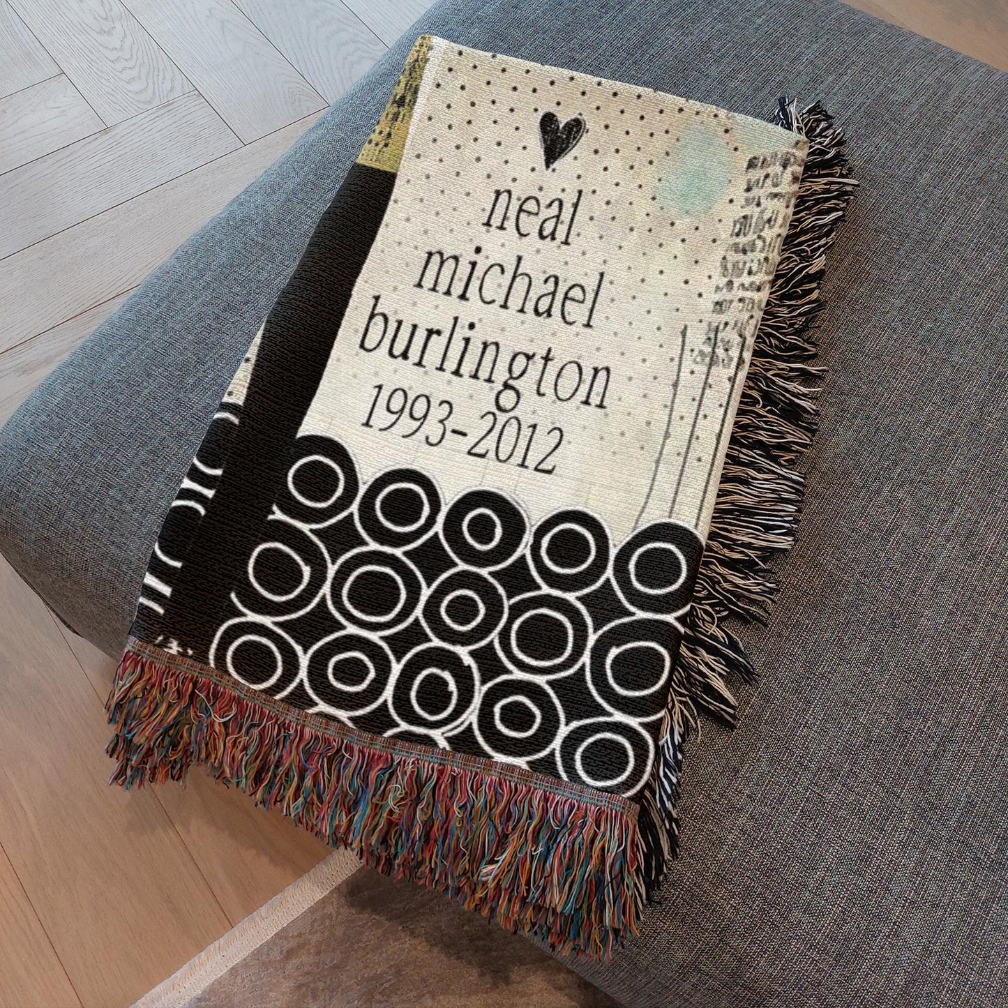 Memorial blanket with text and patterns on a gray surface