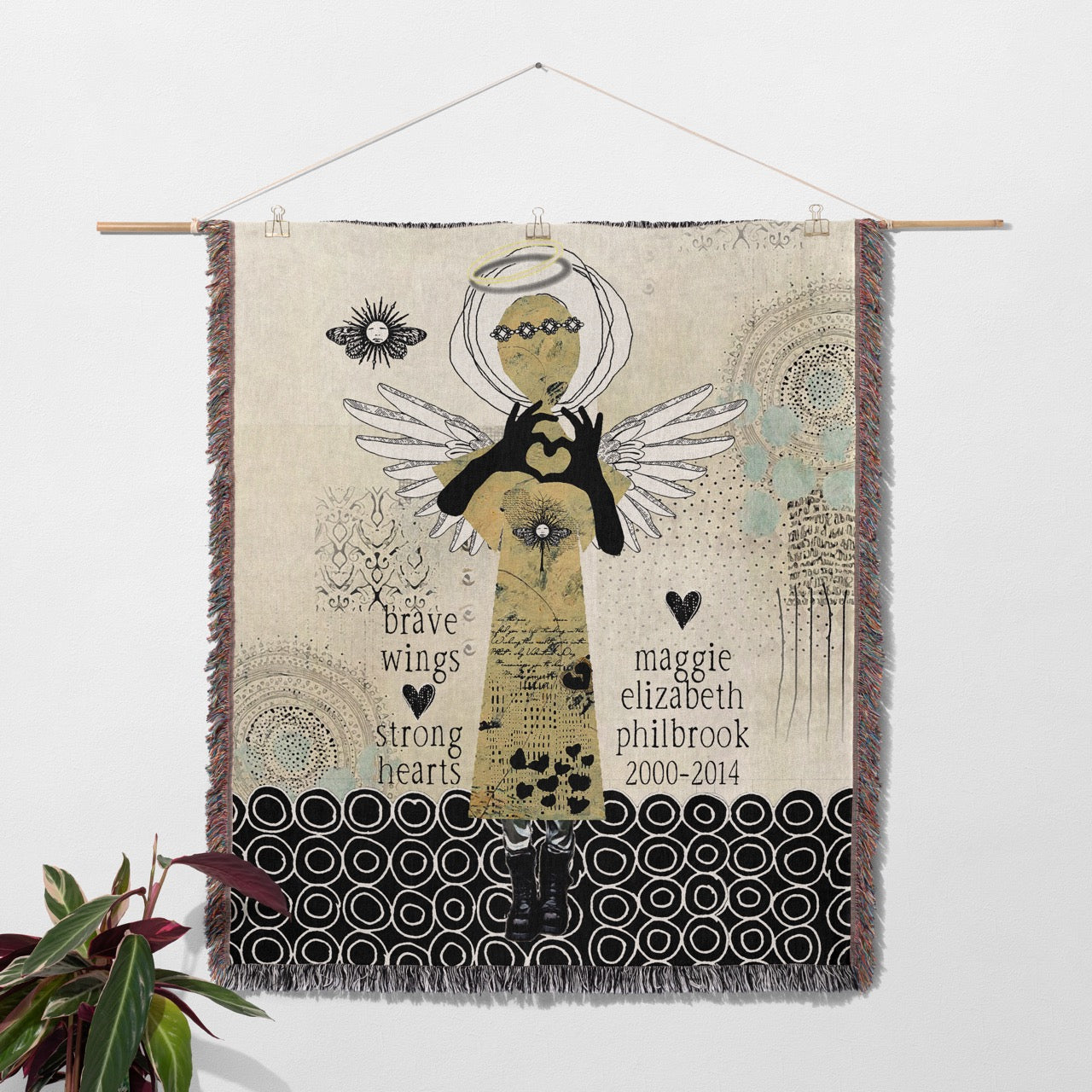 Decorative wall hanging with angel design and text on a neutral background