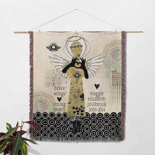 Decorative wall hanging with angel design and text on a neutral background
