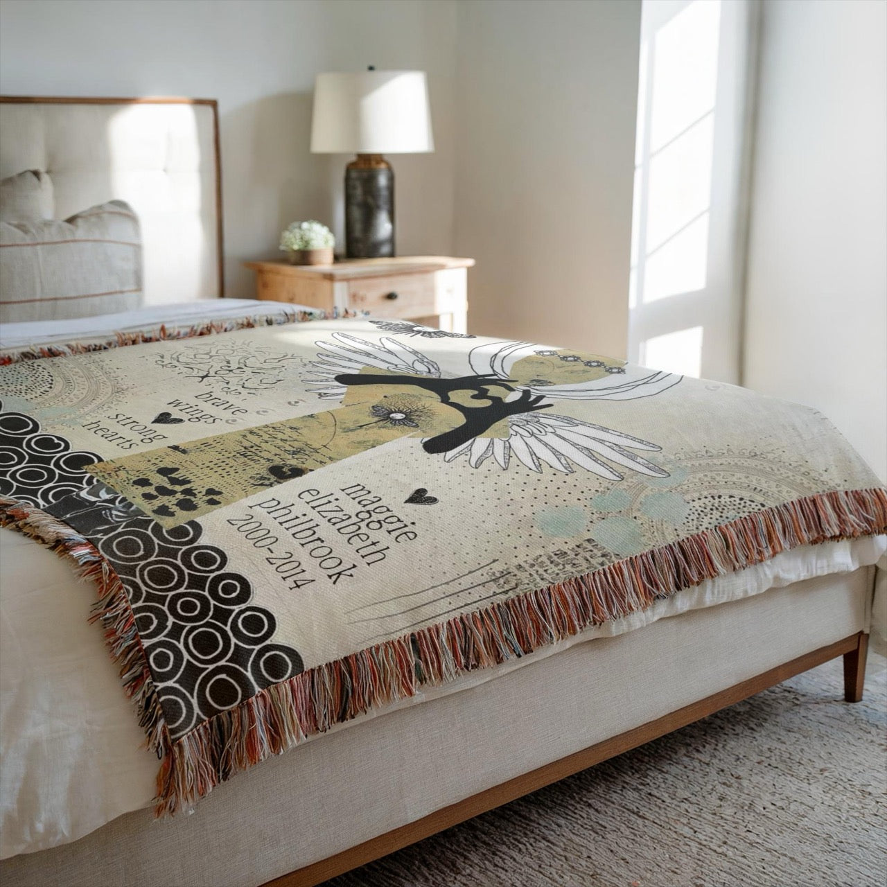 Decorative blanket with angel design on a bed in a bedroom setting