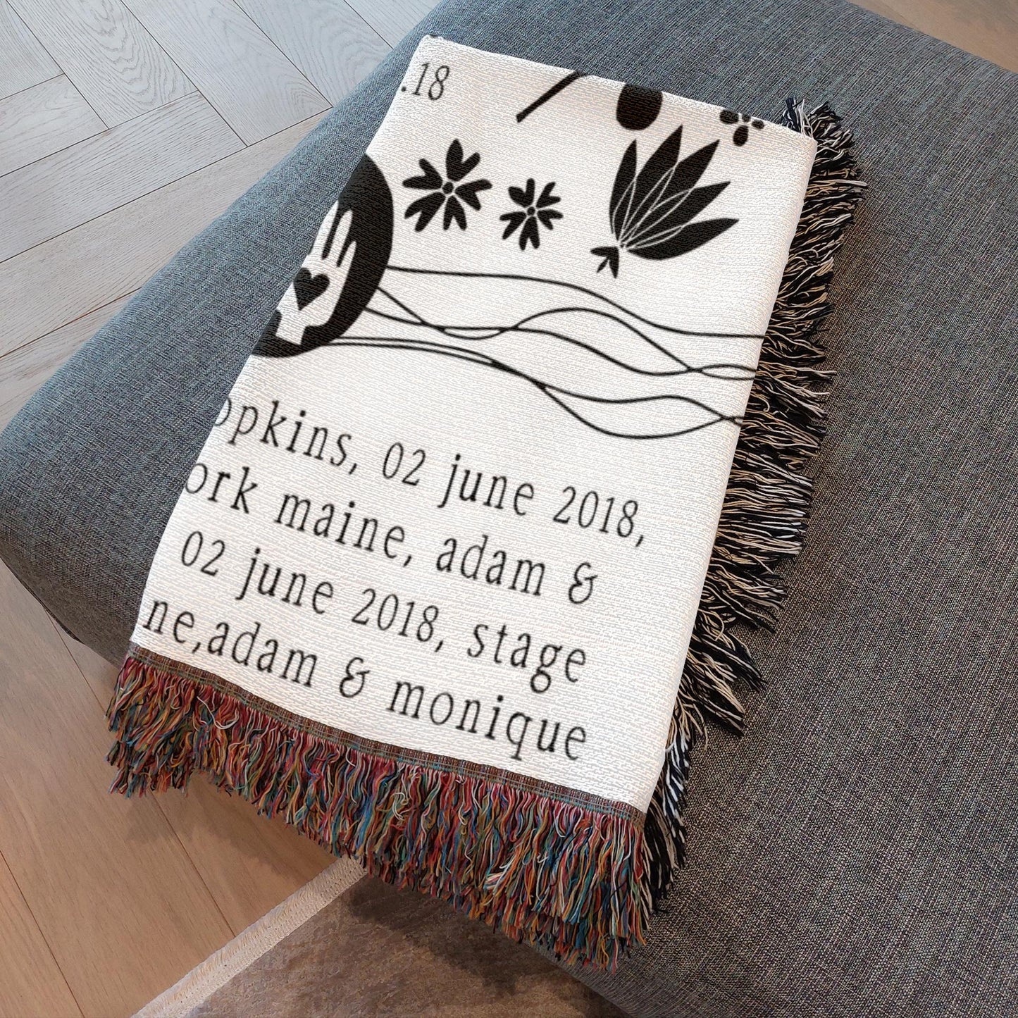 Blanket with text and decorative elements on a gray surface