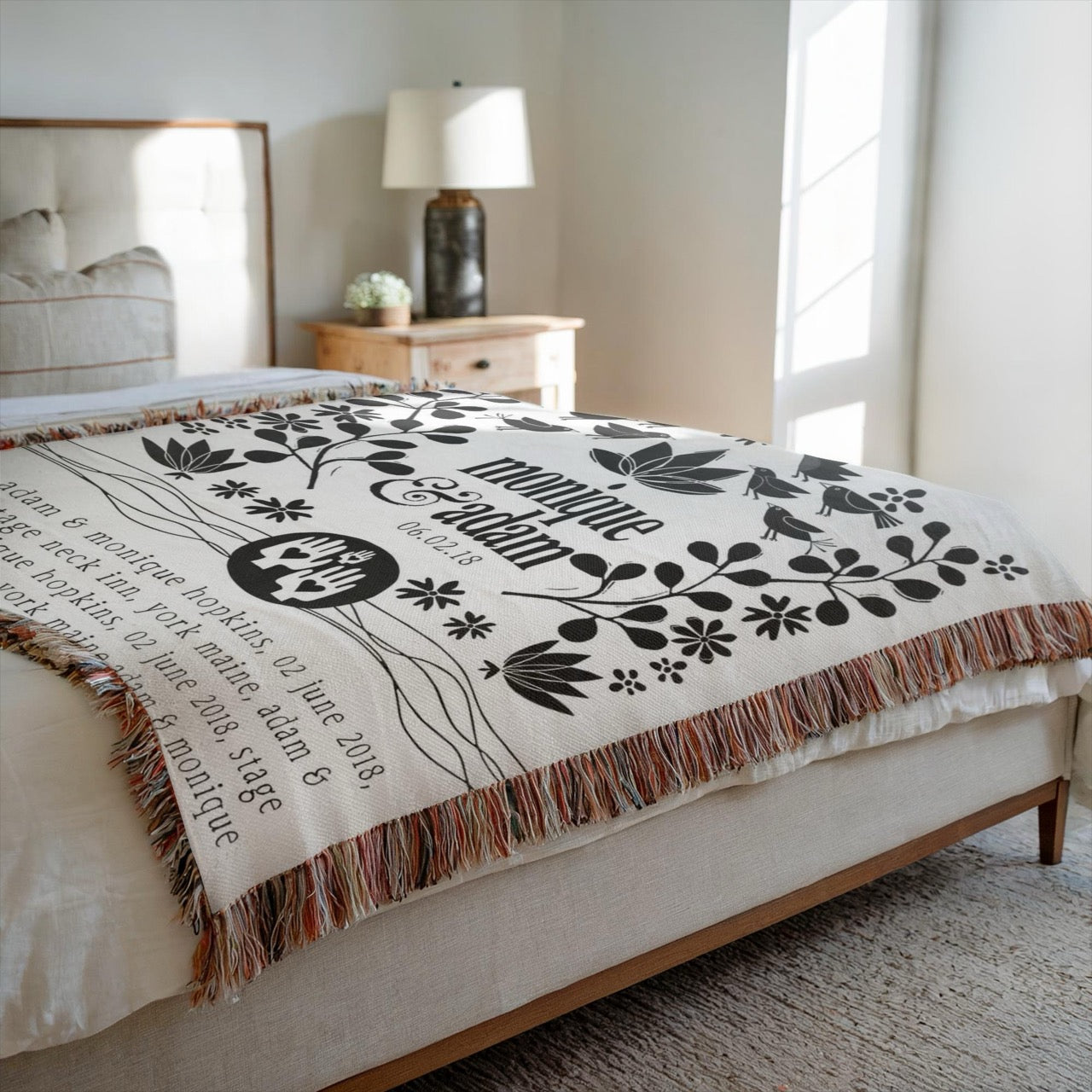 Decorative blanket with floral and text design on a bed in a bedroom.