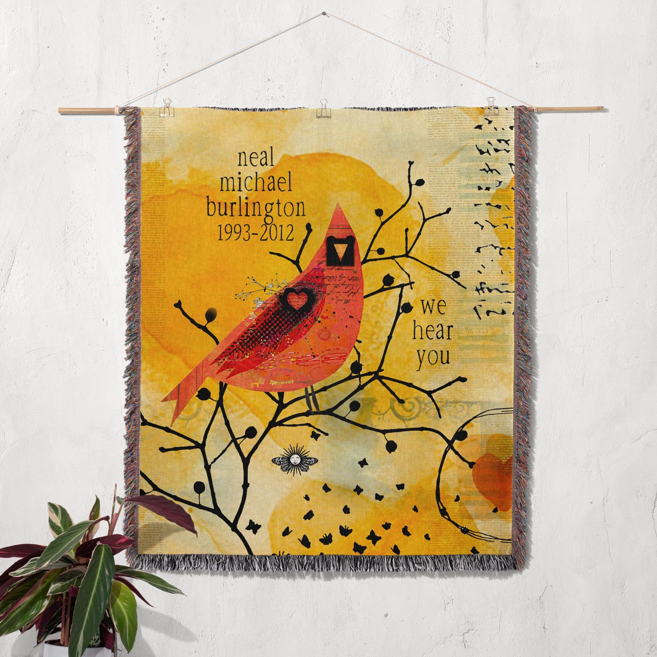 Woven tapestry with a red bird design and text on a white wall.