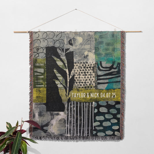 Textile art piece with patterns and text on a white wall