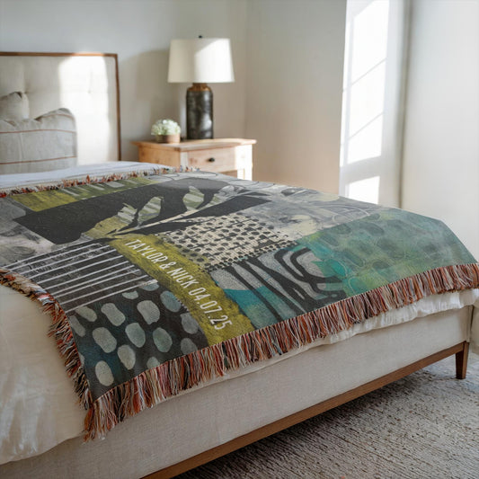 Patterned blanket on a bed in a bedroom with a lamp and nightstand.