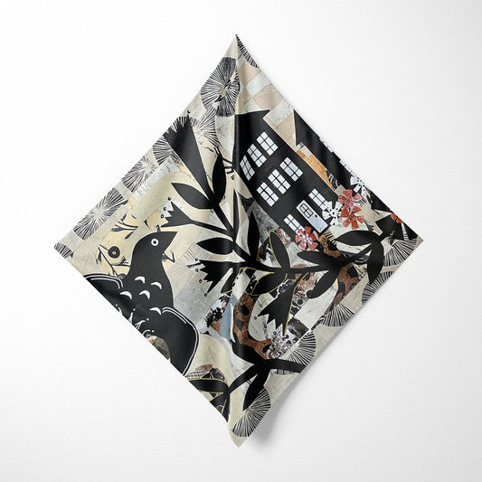 Folded fabric with a black and white pattern of birds and buildings on a white background