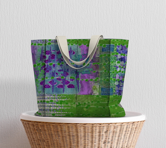 A large multicolored tote bag with a vibrant floral pattern in shades of green and purple, with a solid blue lining and white straps.